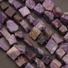 Close-up of purple and brown stone beads on a dark surface