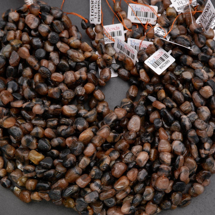 Close-up of a string of small, multicolored stones with price tags on a gray background