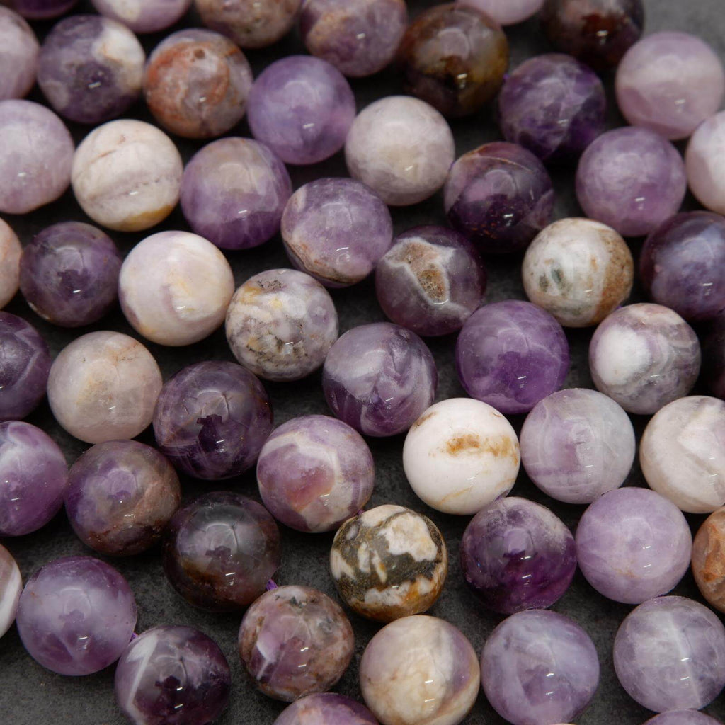 Close-up of purple and white marbled beads on a dark surface