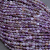 Close-up of a string of purple beads on a gray background