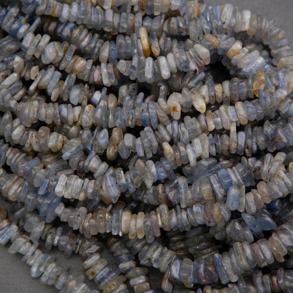Close-up of a pile of small, rough-cut stones on a gray background