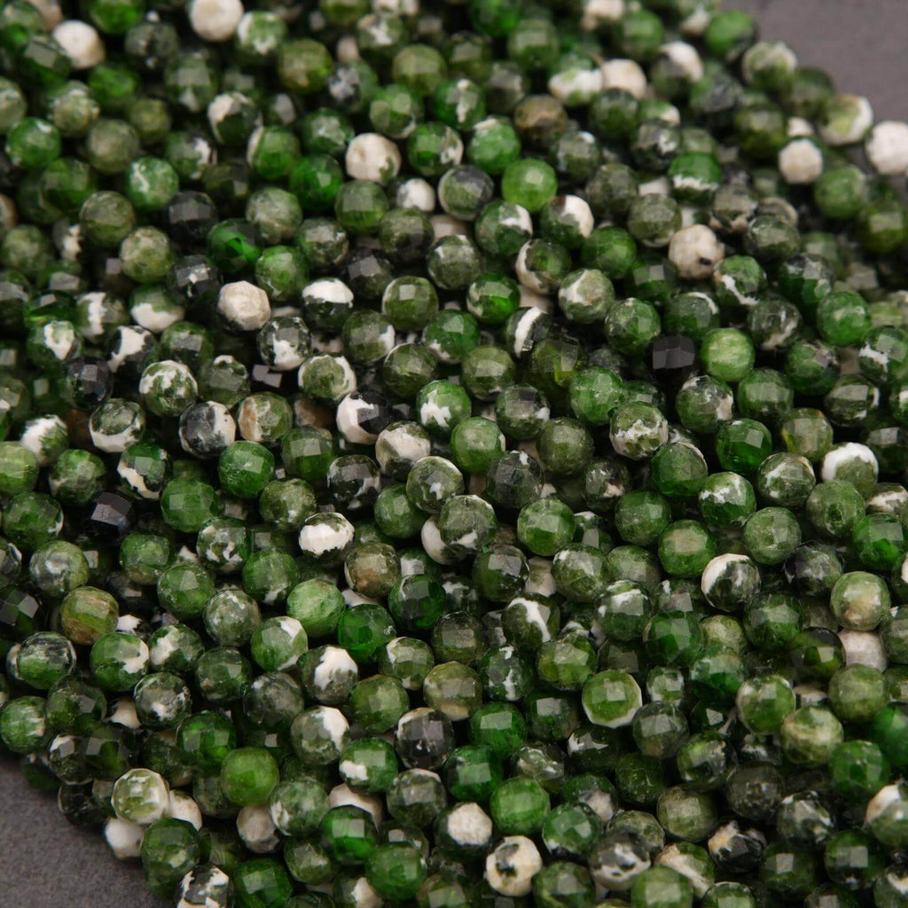 Close-up of green and white faceted beads on a dark background