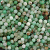 Macro view of Chrysoprase beads highlighting their translucent green color and brown mineral inclusions.