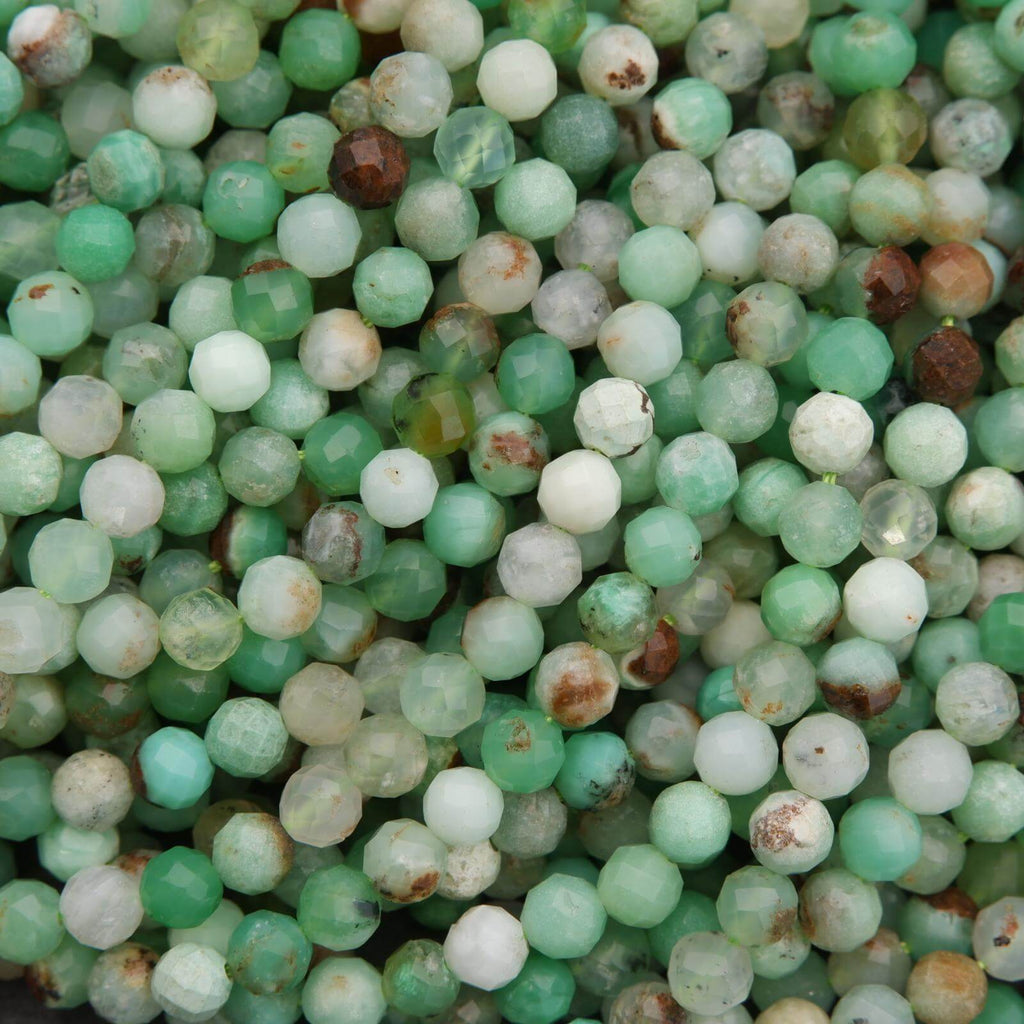 Macro view of Chrysoprase beads highlighting their translucent green color and brown mineral inclusions.