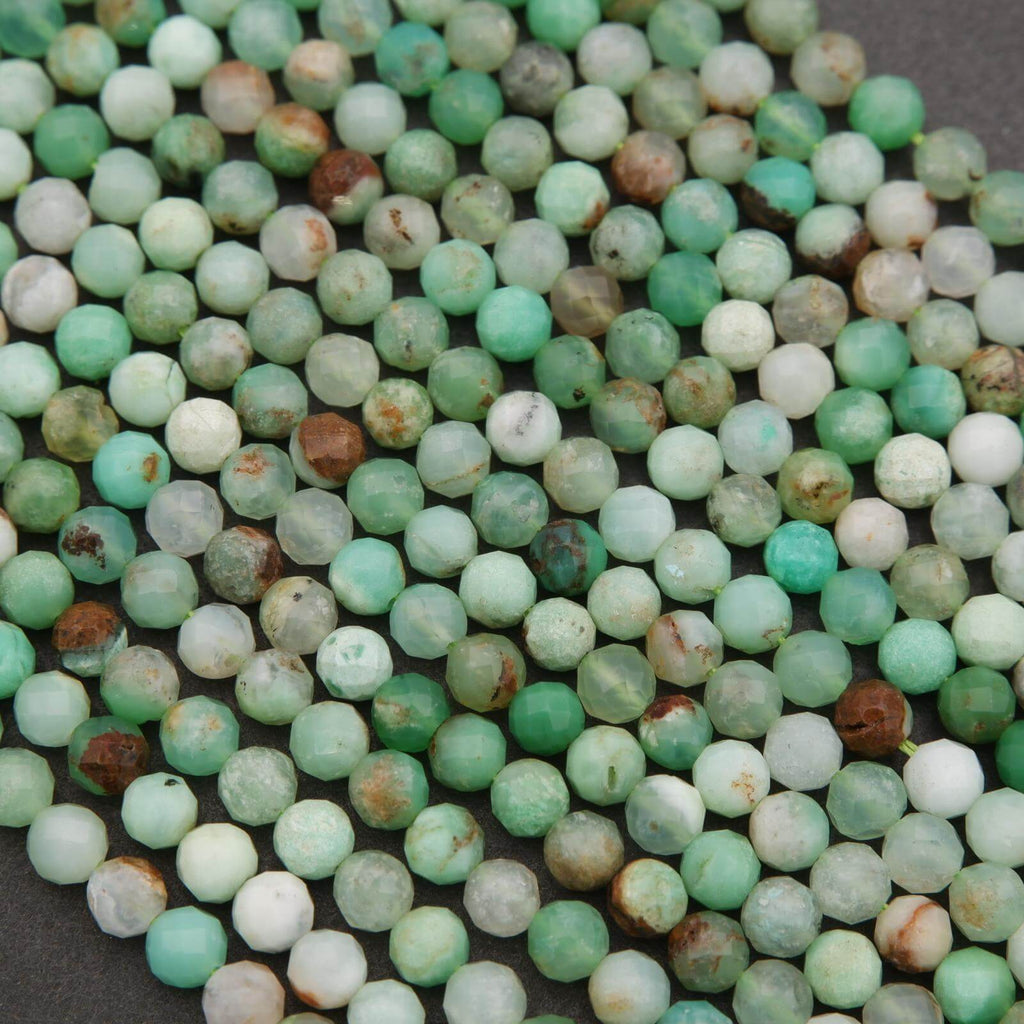 Close-up of faceted round Chrysoprase beads in varying shades of green, with natural brown and white matrix inclusions.