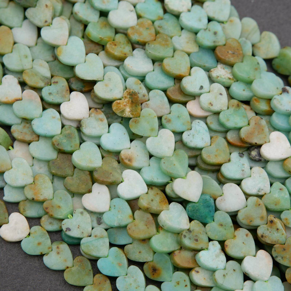 Heart-shaped stones in various shades of green and white on a dark surface