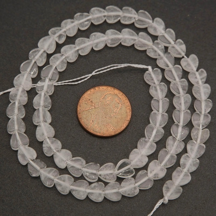 Close-up of clear quartz beads on a gray surface