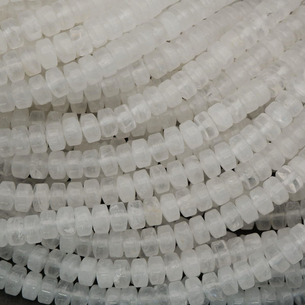 Macro image of clear quartz heishi beads highlighting internal veils and natural crystal structure.