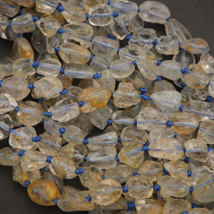 Close-up of a beaded necklace with clear and amber beads on a dark background