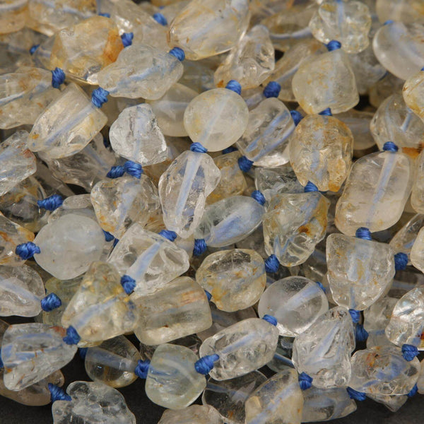 Close-up of small translucent bottles with blue caps and clear liquid on a dark background