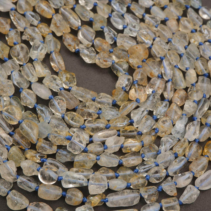 Close-up of a necklace with clear and amber-colored beads on a dark background