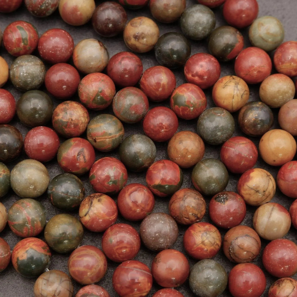 Close-up of marbled red, green, and brown spheres on a dark surface