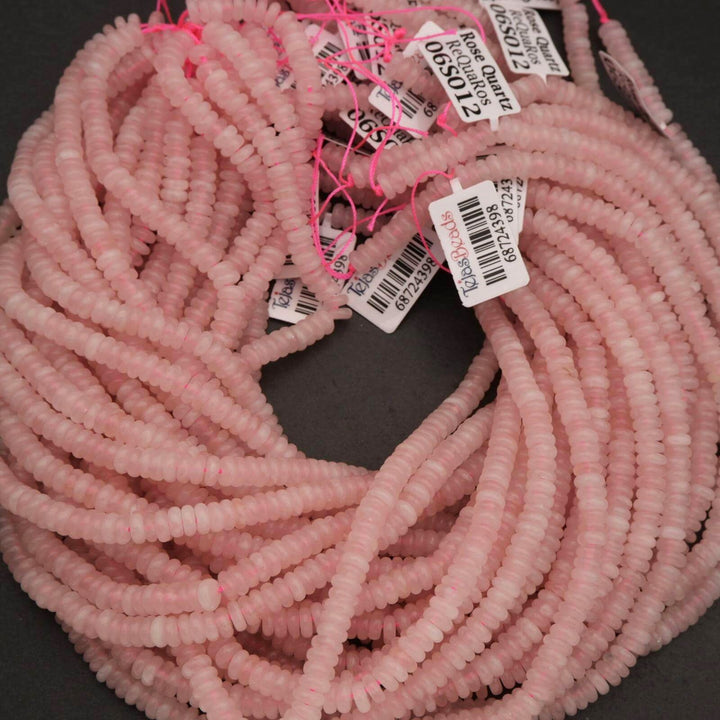 Pink beads with price tags on a dark surface