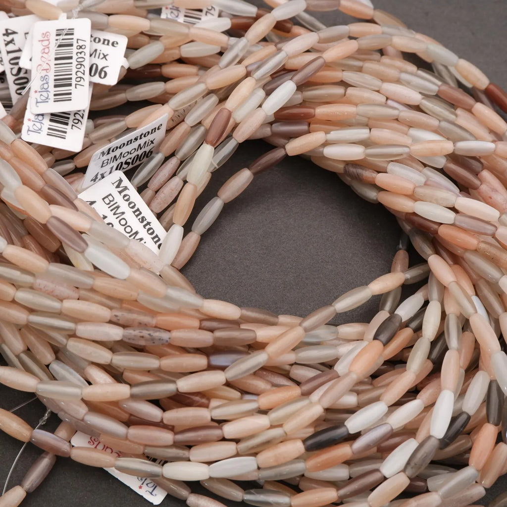 Close-up of a spool of multicolored beads with labels on a gray background