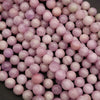 Close-up of pink and purple marbled beads on a black background