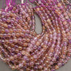 String of pink and purple beads on a gray background