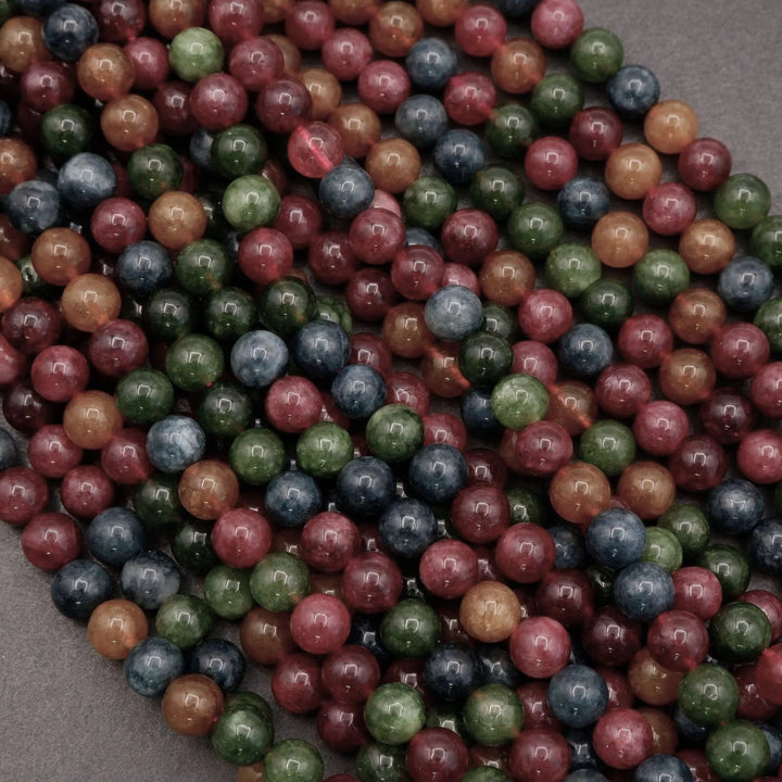Multicolor Jade beads feature a vibrant mix of reds, greens, ambers, and blues with natural variation throughout each strand.