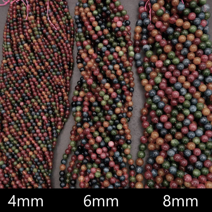 Multicolor Jade beads feature a vibrant mix of reds, greens, ambers, and blues with natural variation throughout each strand.