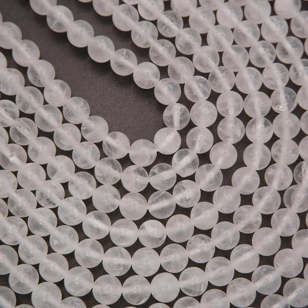 High resolution close up of polished white milky quartz round beads on multiple strands