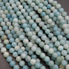 Close-up of light blue and white beads on a dark surface