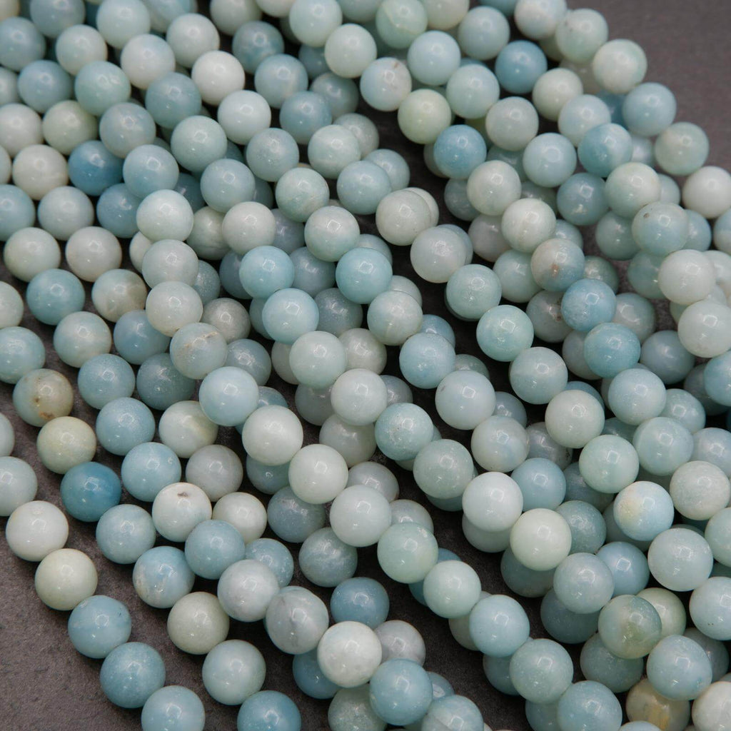 Close-up of light blue and white beads on a dark surface