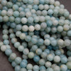 Close-up of light blue and white beads on a dark background
