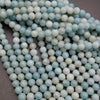 Close-up of light blue and white beads on a dark background