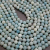 Close-up of light blue and white beads on a dark background