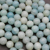 Close-up of light blue and white beads on a gray background