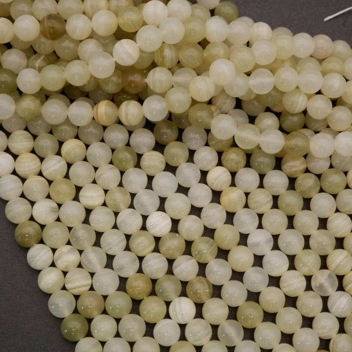 Close-up of light-colored beads on a dark surface