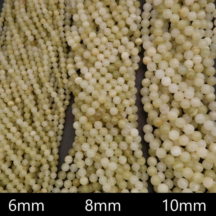 Close-up of three strands of small white beads labeled 6mm, 8mm, and 10mm.