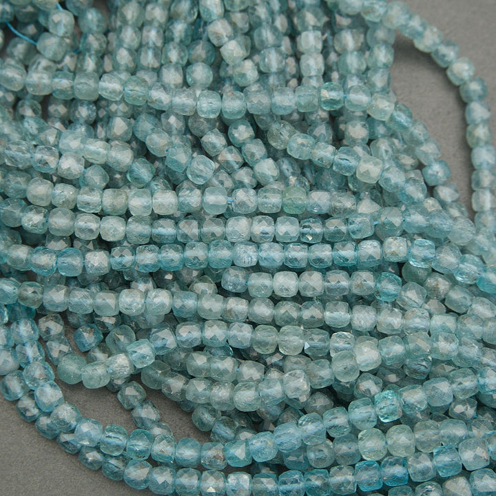 Close-up of a string of light blue beads on a gray background