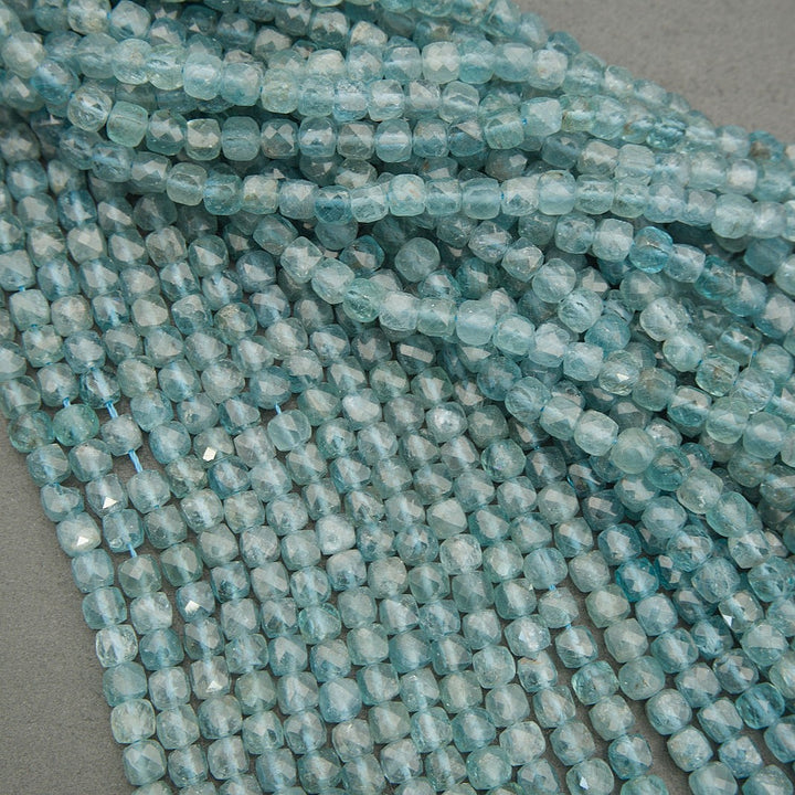 Close-up of light blue beads on a gray surface