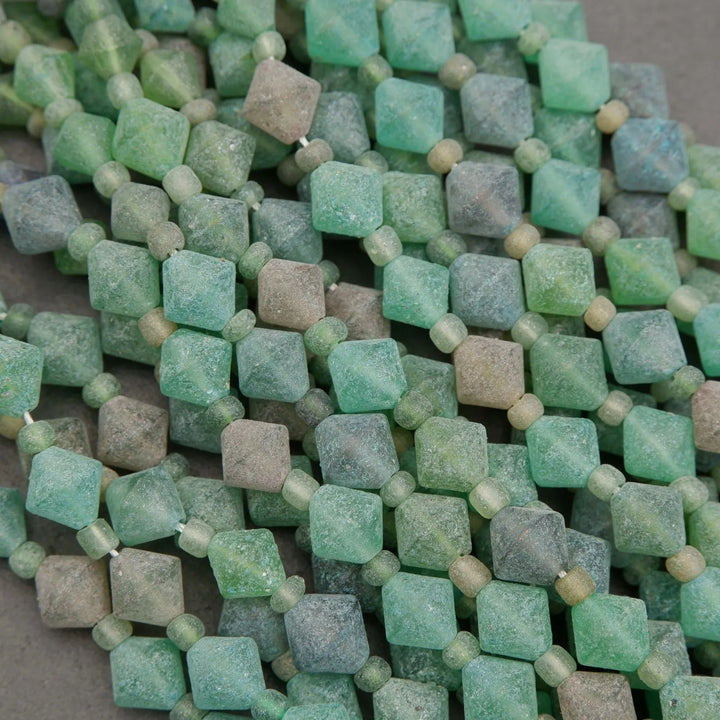 Close-up of green square beads on a gray surface