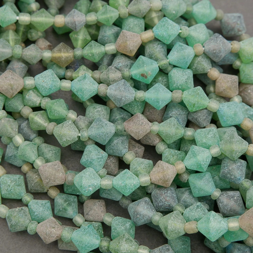 Close-up of green and brown beads on a gray surface