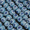 Blue beads with floral patterns on a black background