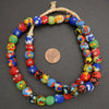 Colorful beaded necklace with a penny for scale on a gray background
