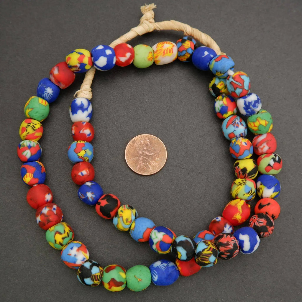 Colorful beaded necklace with a penny for scale on a gray background