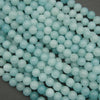 Close-up of light blue beads on a dark background