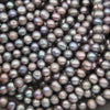 Close-up of potato-shaped peacock freshwater pearls in charcoal gray with blue, green and violet overtones
