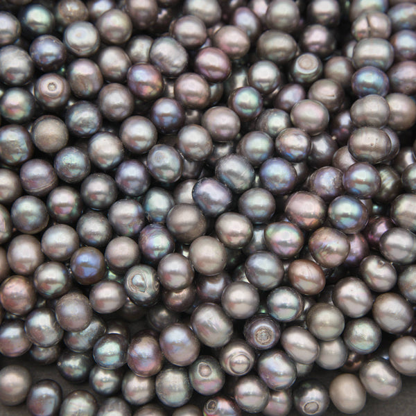 Close-up of potato-shaped peacock freshwater pearls in charcoal gray with blue, green and violet overtones