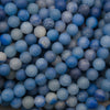 Close-up of matte round dyed blue aventurine beads in denim and cobalt blue with a frosted finish