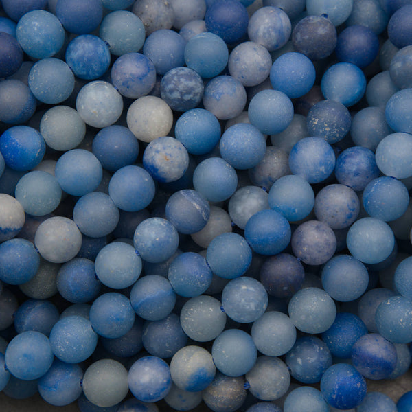 Close-up of matte round dyed blue aventurine beads in denim and cobalt blue with a frosted finish