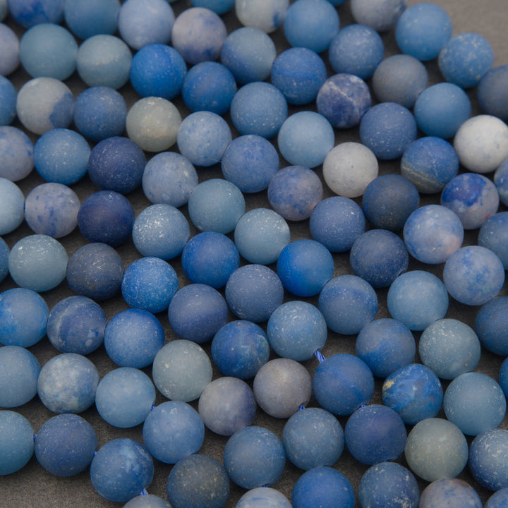 Close-up of matte blue aventurine beads with a soft frosted surface in denim and cobalt blue