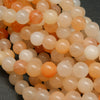 Peach Aventurine Beads showing a mix of hues from light to dark peach, with an almost orange appearance.