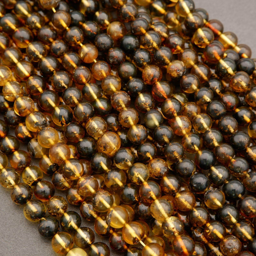 Close-up of a string of black and gold beads on a gray background