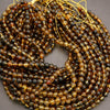 Close-up of a string of black and gold beads on a gray background
