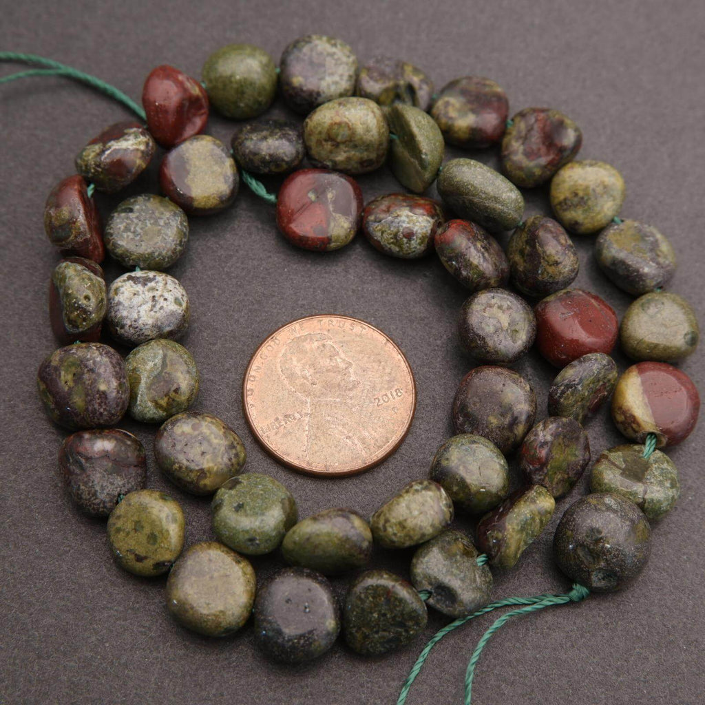 Beads with a penny for size comparison on a gray background