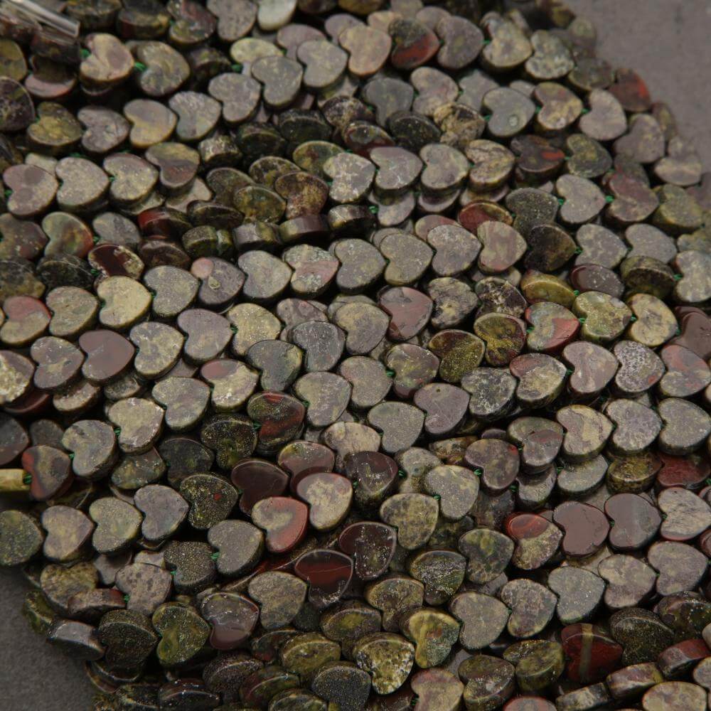 Close-up of small heart-shaped stones in various colors on a dark background
