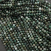 Close-up of green and white beads on a dark background